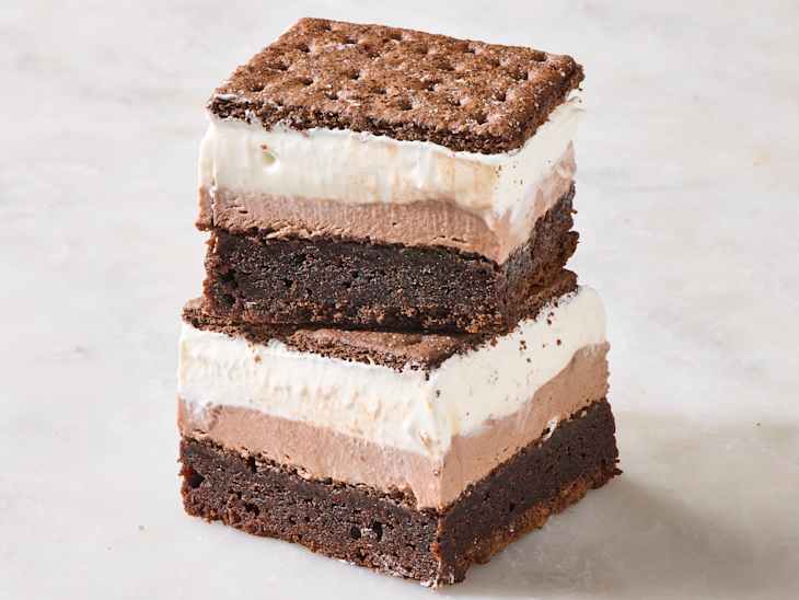 Layered dessert squares with chocolate brownie base, chocolate and vanilla ice cream layers, topped with chocolate wafer.